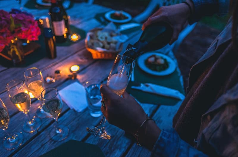 Glasses and candles on a table at dusk