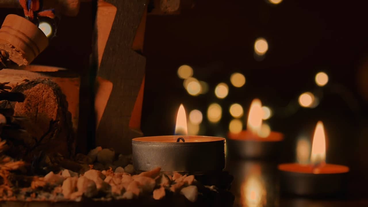 Tealight candles and warm out-of-focus lights on a dark table